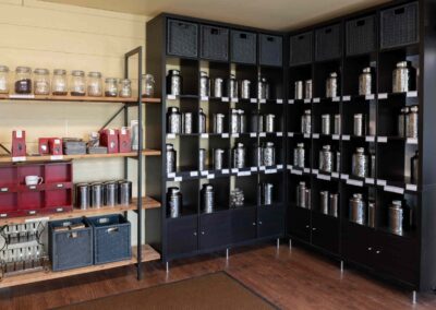 Wooden shelves full of jars of tea of various types